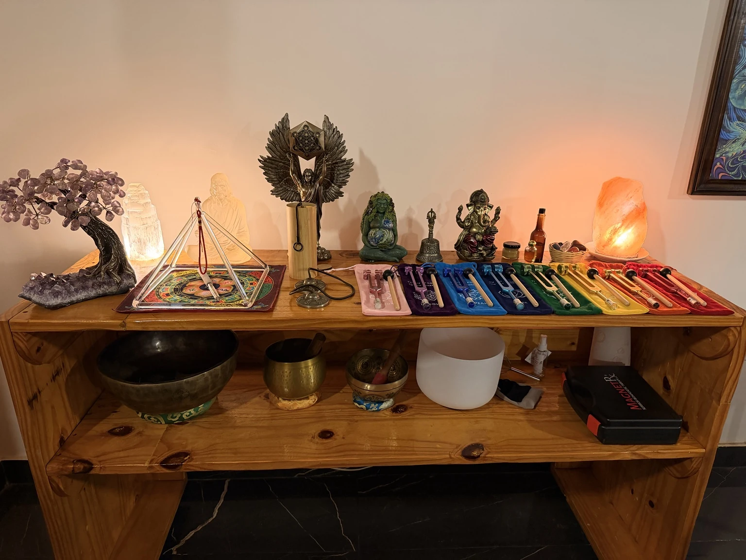 Mesa con cuencos, pirámide de cristal, diapasones y otros recursos de las sesiones.