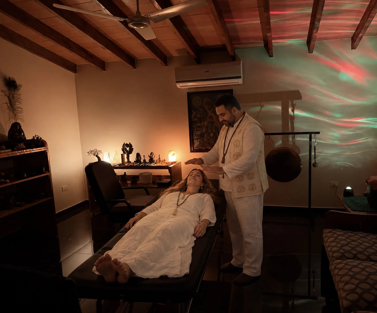 Sergio realizando Reiki a Mabel en el consultorio, junto al gong y los instrumentos.